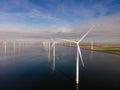 Offshore windmill park with clouds and a blue sky, windmill park in the ocean drone aerial view with wind turbine