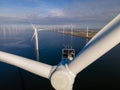 Offshore windmill park with clouds and a blue sky, windmill park in the ocean drone aerial view with wind turbine