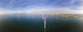 Offshore windmill park with clouds and a blue sky, windmill park in the ocean drone aerial view with wind turbine