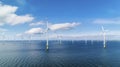 Offshore windmill park with clouds and a blue sky. Generative AI