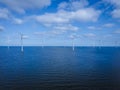 offshore windmill park with clouds and a blue sky, windmill park in the ocean drone aerial view with wind turbine