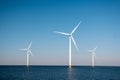 Offshore windmill park green energy in the Netherlands Europe, wind mill turbines at sea and land providing green energy Royalty Free Stock Photo