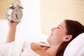 Oh dear, Ive slept all day. A gorgeous young woman smiling while looking at her alarm clock. Royalty Free Stock Photo