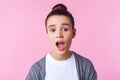 Oh my god wow! Portrait of amazed cute brunette teenage girl looking at camera with widely open mouth. isolated on pink background