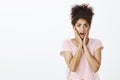 Oh no, it is bad. Portrait of sympathizing good-looking worried woman with combed curly hair, dropping jaw and holding Royalty Free Stock Photo