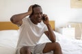 Oh No. Stresses Black Man Sitting On Bed And Talking On Cellphone Royalty Free Stock Photo