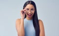 Oh wow. Cropped portrait of an attractive young woman peering over her glasses while standing against a grey background Royalty Free Stock Photo