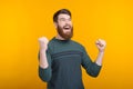 Oh yeah, I got it. Happy bearded guy is making the winner gesture on yellow background Royalty Free Stock Photo