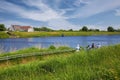 Path with waiting cyclists for small bicycle passenger ferry boat over Maas river to belgian border town Ophoven on the other side