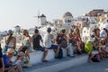 Crowds of tourists waiting for sunset at the castle with windmill and dome in background in Oia, Santorini, Greece Royalty Free Stock Photo