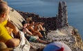 Young tourists sitting and waiting for sunset at the castle of Oia, Santorini, Greece Royalty Free Stock Photo
