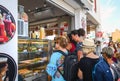 Tourists line up at a small sandwich and juice shop at the touristic village of Oia on the island of Santorini, Greece.