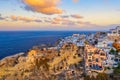 Oia village with traditional white houses, windmills and castle during colorful sunrise. Santorini island, Greece Royalty Free Stock Photo