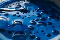 Oil blue paint with big bubbles in a round container in the sun. Royalty Free Stock Photo