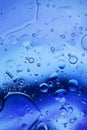 Oil bubbles in water . Blue and black colors tog hater. Royalty Free Stock Photo