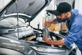 Oil can in hands. Auto mechanic working in garage. Repair service Royalty Free Stock Photo