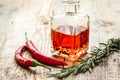 oil in carafe with spices and chili on wooden background mock-up