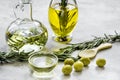 Oil in carafe with spices and olive on stone background