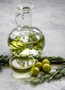 Oil in carafe with spices and olive on stone background