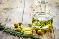 Oil in carafe with spices and olive on wooden background mock-up