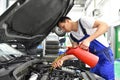 oil change from the engine of a car in a workshop by a professional mechanic - after-sales service Royalty Free Stock Photo