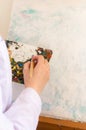 Oil color palette and female human hand holding brush, artist creative painting process. Woman drawing on canvas Royalty Free Stock Photo