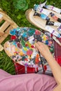 Oil color palette and female human hand holding brush, woman artist painting process outdoor in the park view from above Royalty Free Stock Photo