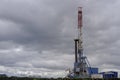 Oil drilling rig on the field. Oil field, Onshore drilling rig around with agriculture field. View from the another site of sugar