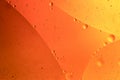 Oil drops on a water surface, orange abstract macro background. Royalty Free Stock Photo