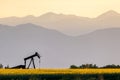 Oil field pump and mountain sunset