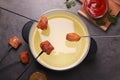 Oil in fondue pot, forks with fried meat pieces and sauces on grey table, flat lay Royalty Free Stock Photo