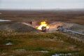 Oil, gas industry. Group wellheads and valve armature , Gas flare vertical installation, Gas burning torch against the sunset sky