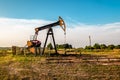 Oil and gas industry. Working oil pump jack on oil field at sunset Royalty Free Stock Photo