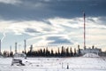 Oil and gas plant with a flare stack and flame under a dramatic winter sky in Western Canada Royalty Free Stock Photo