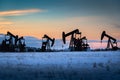 Oil and gas pump jacks working at sunset in Alberta Canada