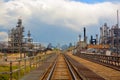 Oil and Gas Refinery Distillation Towers with Railroad Tracks and a Distant City