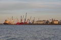 Oil and gas tanks in Hamburg harbor with ships, cranes and boats. River Elbe in the foregrond