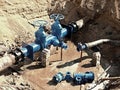 Oil, gas, water industry. Wellhead with valve armature underground. Dug deep trench Royalty Free Stock Photo
