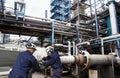 Oil and gas workers inside large refinery industry Royalty Free Stock Photo