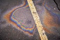 Oil, gasoline, or oil spill on wet asphalt with a parking lot and a dividing line. Royalty Free Stock Photo