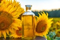 oil in a glass bottle against the background of blooming sunflowers in the field
