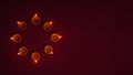 Oil lamps lit on dark background wit circular formation and copy space, Diwali backgrounds , clay oil lamps