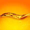 Oil liquid with bubbles. Golden wave on yellow background. For the adwiesting projects with oil, honey, beer, shampoo, hygiene Royalty Free Stock Photo