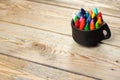 Oil pastel crayons in a mug on a wooden table Royalty Free Stock Photo