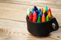 Oil pastel crayons in a mug on a wooden table Royalty Free Stock Photo