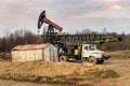 Oil pump and mobile drilling rig at sunset Royalty Free Stock Photo