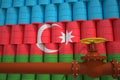 Oil pipe and barrels with painted flag of Azerbaijan. Petroleum industry related 3d rendering