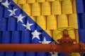 Oil pipe and barrels with painted flag of Bosnia. Petroleum industry related 3d rendering