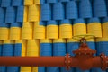 Oil pipe and barrels with painted flag of Sweden. Petroleum industry related 3d rendering