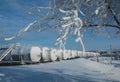 White tanks in tank farm with iron staircase in snow Royalty Free Stock Photo